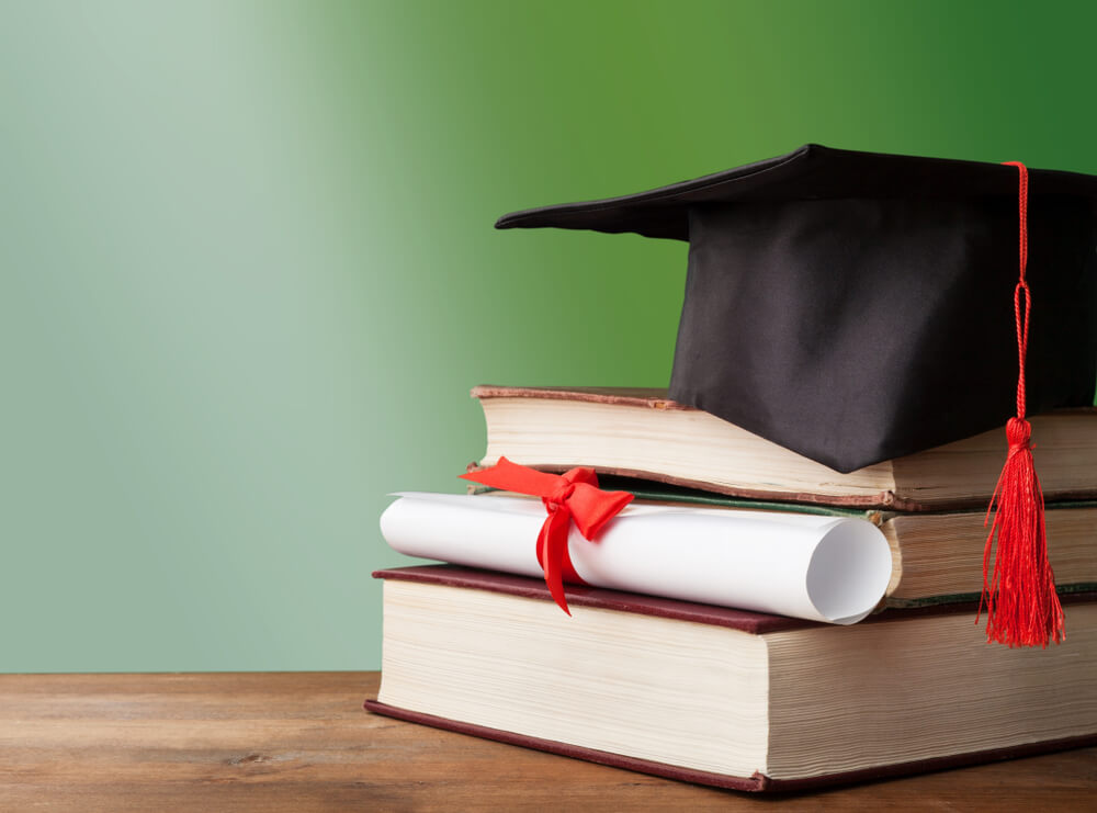 graduation hat stacked on books